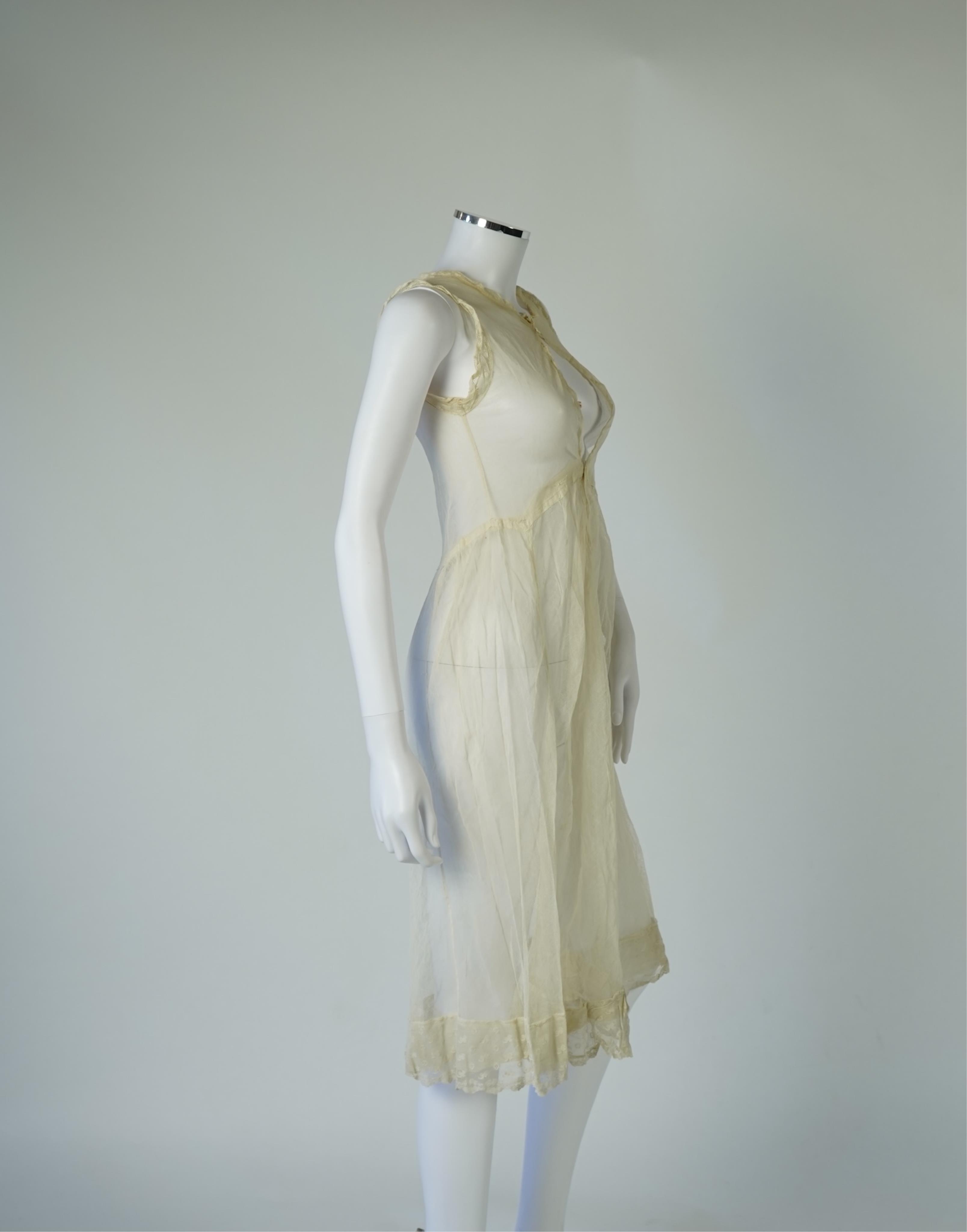 An early 20’s cream net ladies summer dress and net petticoat, designed with a lace inset front skirt, yolk and sleeves.103cm long. Condition - both need re-laundering and some seams tidying.